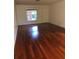 Bright living room with hardwood floors, a window overlooking the yard, and a neutral color palette at 507 Bates Ave, Eustis, FL 32726