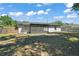 Wide view of the backyard featuring a covered patio and chain link fence at 525 Oak Dr, Tavares, FL 32778