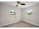 Bedroom features neutral paint, a ceiling fan, wood-look floors and two large windows at 525 Oak Dr, Tavares, FL 32778