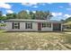 Charming single-story home with a red front door, black shutters, and a well-maintained front yard at 525 Oak Dr, Tavares, FL 32778