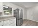 Bright kitchen features granite counters, white cabinets, stainless steel refrigerator, and wood-look floors at 525 Oak Dr, Tavares, FL 32778