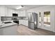 Modern kitchen with stainless steel appliances, granite counters, ample white cabinetry, and backyard access at 525 Oak Dr, Tavares, FL 32778
