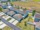 Aerial view of townhomes with landscaping, parking, and nearby green space at 534 Juniper Springs Dr, Groveland, FL 34736