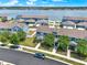 Aerial view of blue townhomes near a lake with driveways and landscaping at 534 Juniper Springs Dr, Groveland, FL 34736