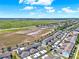 Aerial view of townhomes with a nearby field under a blue sky at 534 Juniper Springs Dr, Groveland, FL 34736
