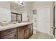 This bathroom features a tiled floor, granite countertop, a large mirror, and a walk-in shower at 534 Juniper Springs Dr, Groveland, FL 34736