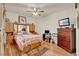 Comfortable bedroom features wood laminate flooring, ceiling fan, and dresser with mounted television at 534 Juniper Springs Dr, Groveland, FL 34736
