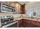 Stainless steel oven and range nestled amongst dark wood cabinets and stone countertops at 534 Juniper Springs Dr, Groveland, FL 34736