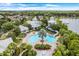 Beautiful view of the community pool with palm trees, lounge chairs, and a thrilling water slide for residents to enjoy at 534 Juniper Springs Dr, Groveland, FL 34736