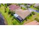 An aerial view of the home featuring a screened lanai, tile roof, and lush landscaping at 537 Montage Ln, Kissimmee, FL 34759