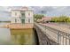 View of lakeside community building featuring beautiful stone bridge and lush landscaping at 537 Montage Ln, Kissimmee, FL 34759