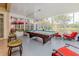 Spacious sunroom boasts a pool table, seating, and view of the lush backyard at 537 Montage Ln, Kissimmee, FL 34759