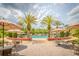 Resort-style pool area with tables, palm trees, umbrellas, and seating for relaxing and socializing at 537 Montage Ln, Kissimmee, FL 34759