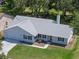 Bird's-eye view of a home with a spacious driveway, lush lawn, and inviting facade in a peaceful neighborhood at 5712 Connors St, Leesburg, FL 34748
