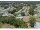 This aerial showcases the neighborhood's peaceful streets and lush greenery near a community lake at 5712 Connors St, Leesburg, FL 34748