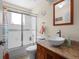 Bright bathroom features a granite countertop and a frameless sliding shower door at 5712 Connors St, Leesburg, FL 34748