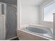 Clean bathroom features tiled shower, large bathtub, and bright window at 5712 Connors St, Leesburg, FL 34748