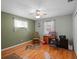 Modest bedroom with a ceiling fan, wood floors, and a chair at 5712 Connors St, Leesburg, FL 34748