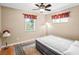 Bedroom shows a simple decor with hardwood floors, ceiling fan and two windows at 5712 Connors St, Leesburg, FL 34748