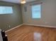 Bright bedroom showcases hardwood floors and natural light from two windows at 5712 Connors St, Leesburg, FL 34748