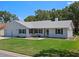 Charming single-story home with a well-manicured lawn, attached garage, and inviting front entrance at 5712 Connors St, Leesburg, FL 34748