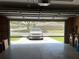 Open garage door shows a clean, organized space with a grey mesh door at 5712 Connors St, Leesburg, FL 34748