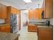 Spacious kitchen with stainless steel refrigerator, granite countertops, and lots of wood cabinets at 5712 Connors St, Leesburg, FL 34748