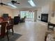 Spacious living room with tile flooring, fireplace, ceiling fans and sliding doors to an enclosed porch at 5712 Connors St, Leesburg, FL 34748