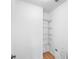 Walk-in closet featuring white walls, wooden floors, and wire shelving units to maximize storage space at 5712 Connors St, Leesburg, FL 34748