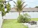 Fenced backyard with palm tree, fire pit, and string lighting at 607 Baldwin Dr, Kissimmee, FL 34758