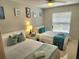 Bright bedroom with two beds, ceiling fan, and window with natural light at 607 Baldwin Dr, Kissimmee, FL 34758