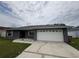 Exterior view of house with large garage and gray paint at 607 Baldwin Dr, Kissimmee, FL 34758