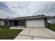 Exterior shot of home with a spacious driveway and an attached two-car garage at 607 Baldwin Dr, Kissimmee, FL 34758
