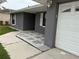 Close up of a front entrance with gray stone landscaping and a single-car garage at 607 Baldwin Dr, Kissimmee, FL 34758