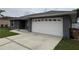 Exterior of home with large garage, stone landscaping and gray paint at 607 Baldwin Dr, Kissimmee, FL 34758