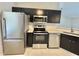 Modern kitchen with stainless steel appliances, dark cabinetry, and light countertops at 607 Baldwin Dr, Kissimmee, FL 34758