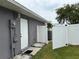 Side yard with white fence, back door to the house, and AC unit at 607 Baldwin Dr, Kissimmee, FL 34758