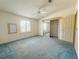 Spacious bedroom with blue carpet, ceiling fan, closet, and natural light from the window at 608 Saint Andrews Blvd, Lady Lake, FL 32159