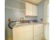 Laundry room with washer, dryer, overhead cabinets, and utility sink for added convenience at 608 Saint Andrews Blvd, Lady Lake, FL 32159