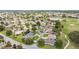 Expansive aerial view of homes with lush green landscaping and a winding golf course with serene ponds in the background at 616 Hartford Ln, The Villages, FL 32162