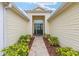 Covered front entryway with vibrant landscaping leading to the front door and glass window above at 616 Hartford Ln, The Villages, FL 32162