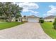 Charming single-Gathering home featuring a brick driveway, lush green lawn, and well-maintained landscaping at 616 Hartford Ln, The Villages, FL 32162