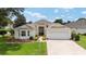 Charming single Gathering home featuring a well-maintained lawn, 2 car garage and covered entryway at 616 Hartford Ln, The Villages, FL 32162