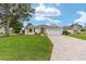 Attractive single-story home with a well-kept lawn, brick driveway, and neat landscaping at 616 Hartford Ln, The Villages, FL 32162