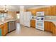 Open kitchen featuring stainless steel dishwasher, gas range, and light wood cabinets at 616 Hartford Ln, The Villages, FL 32162
