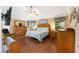 Spacious main bedroom with hardwood floors, ceiling fan, and two windows for natural light at 616 Hartford Ln, The Villages, FL 32162