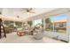 Bright sunroom features a ceiling fan, carpeting, and large windows offering views of the well-manicured backyard at 616 Hartford Ln, The Villages, FL 32162