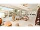Relaxing sunroom boasts comfortable seating, ceiling fans, and a cat tree for feline companionship at 616 Hartford Ln, The Villages, FL 32162