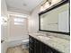 Bathroom featuring a granite countertop, dark cabinets, a tiled shower, and a bath tub at 6259 Se 120Th Pl, Belleview, FL 34420