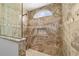 Bathroom shower featuring custom tile work, grab bars, niche, and glass enclosure at 6259 Se 120Th Pl, Belleview, FL 34420